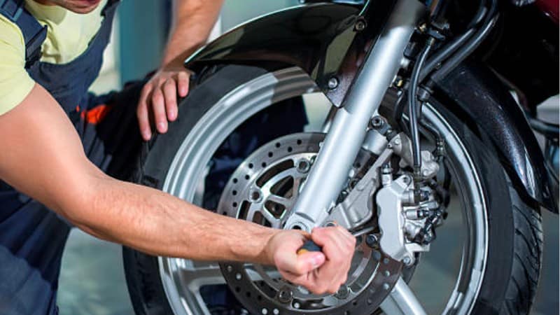 Mechanic fixing motorcycle front wheel