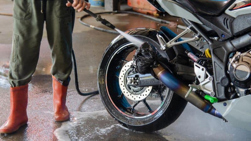 Man Washing Motorcycle At Car Wash Shop